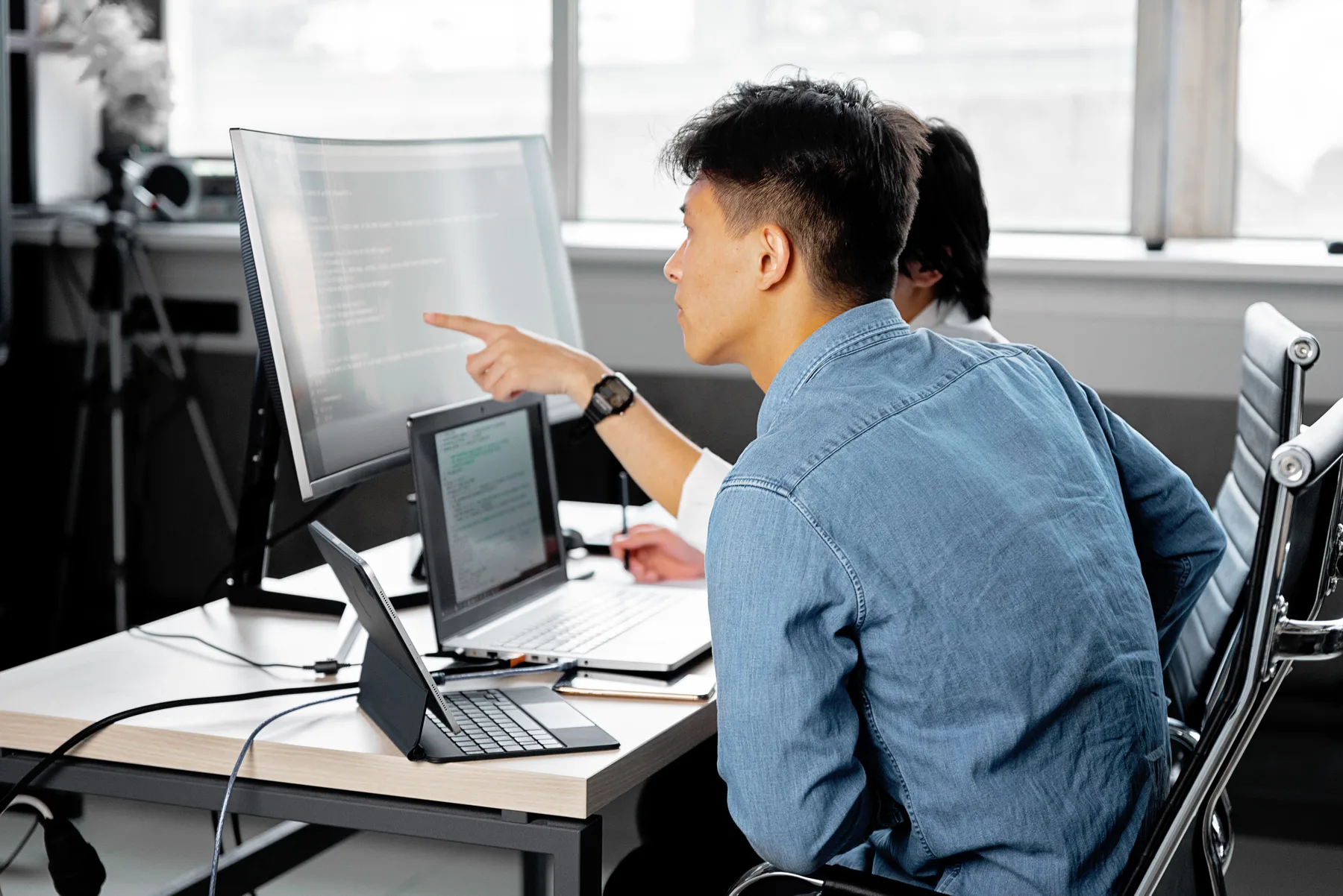 Two developers reviewing code on a monitor