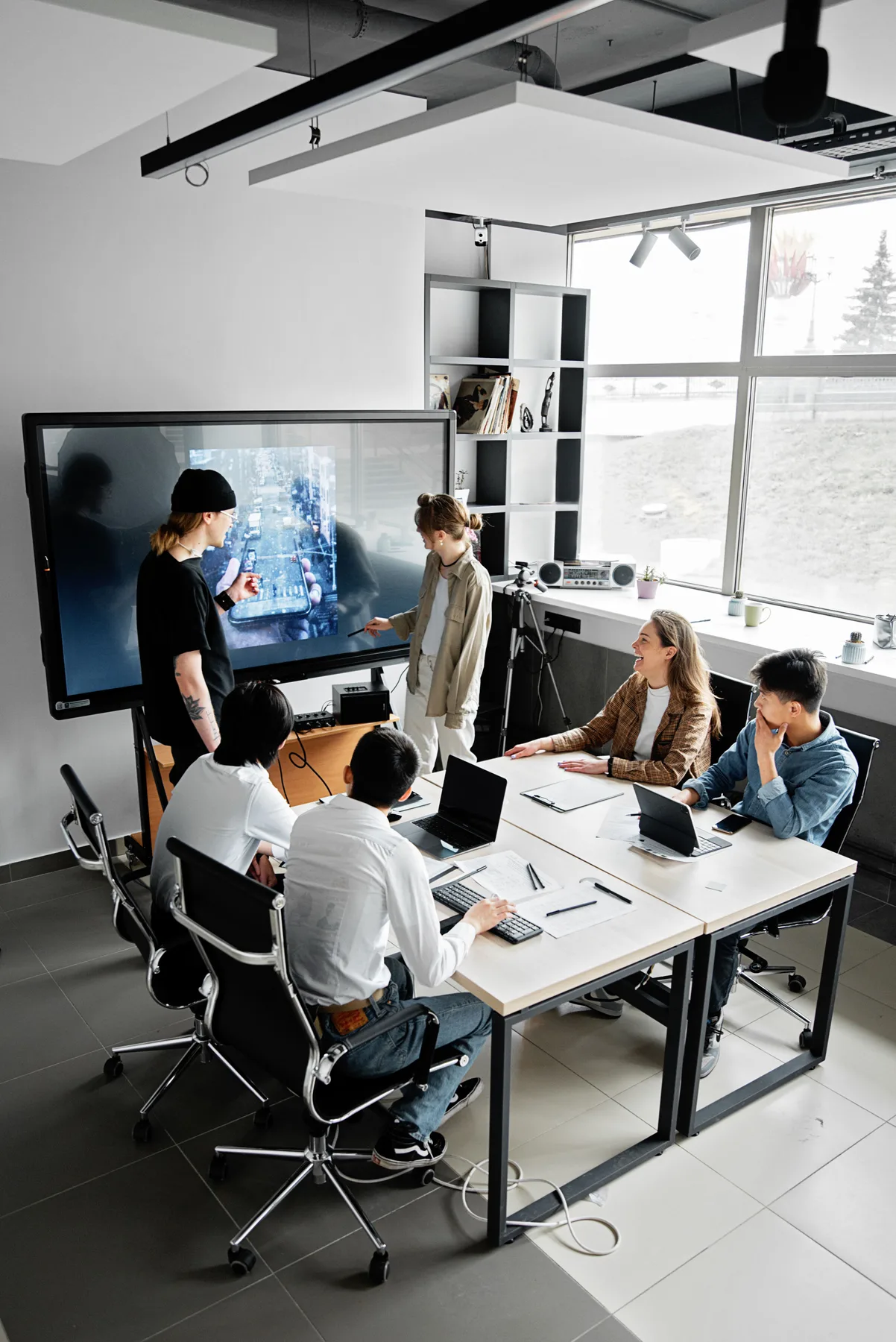 People discussing a presentation around a meeting table